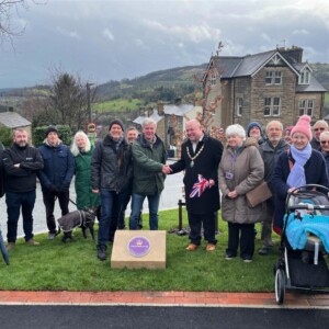 Group photo (mostly local residents) at plaque unveiling 14 March 2023. Ken Parker (MCA) and Paul Cruise (Mayor) shake hands. Photo by Tracey Grant